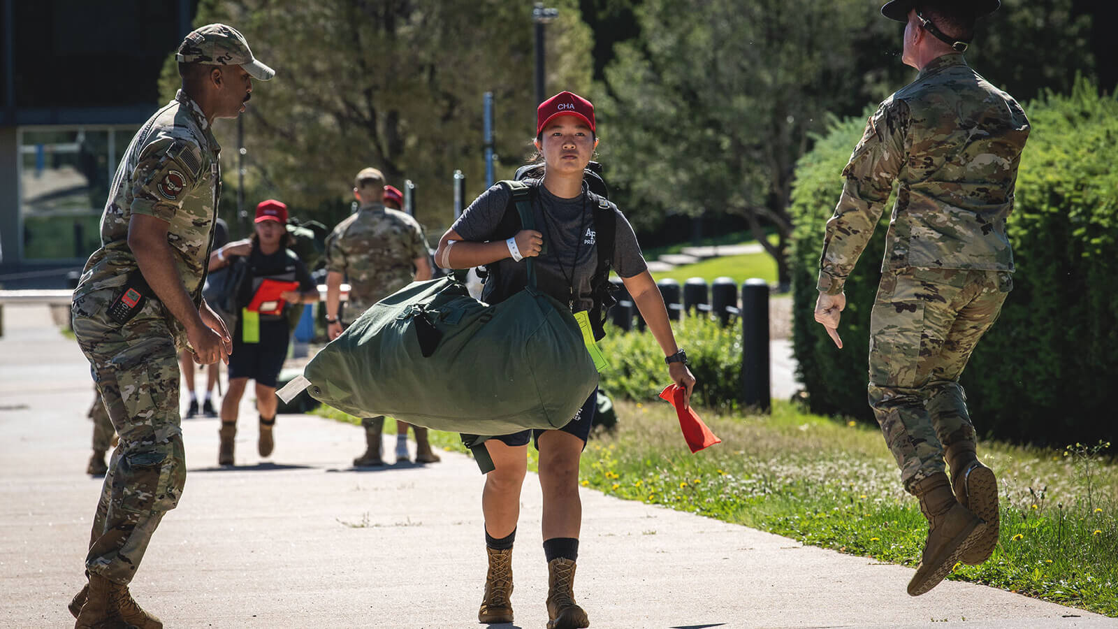 a student and a drill sergeant do PT outside in BDUs
