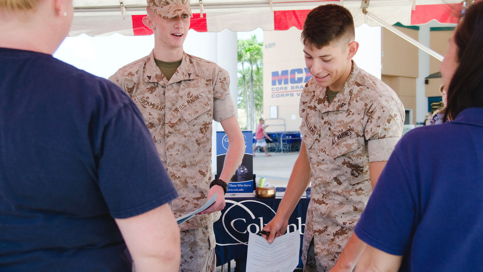 two marines stop by a college recruiting booth