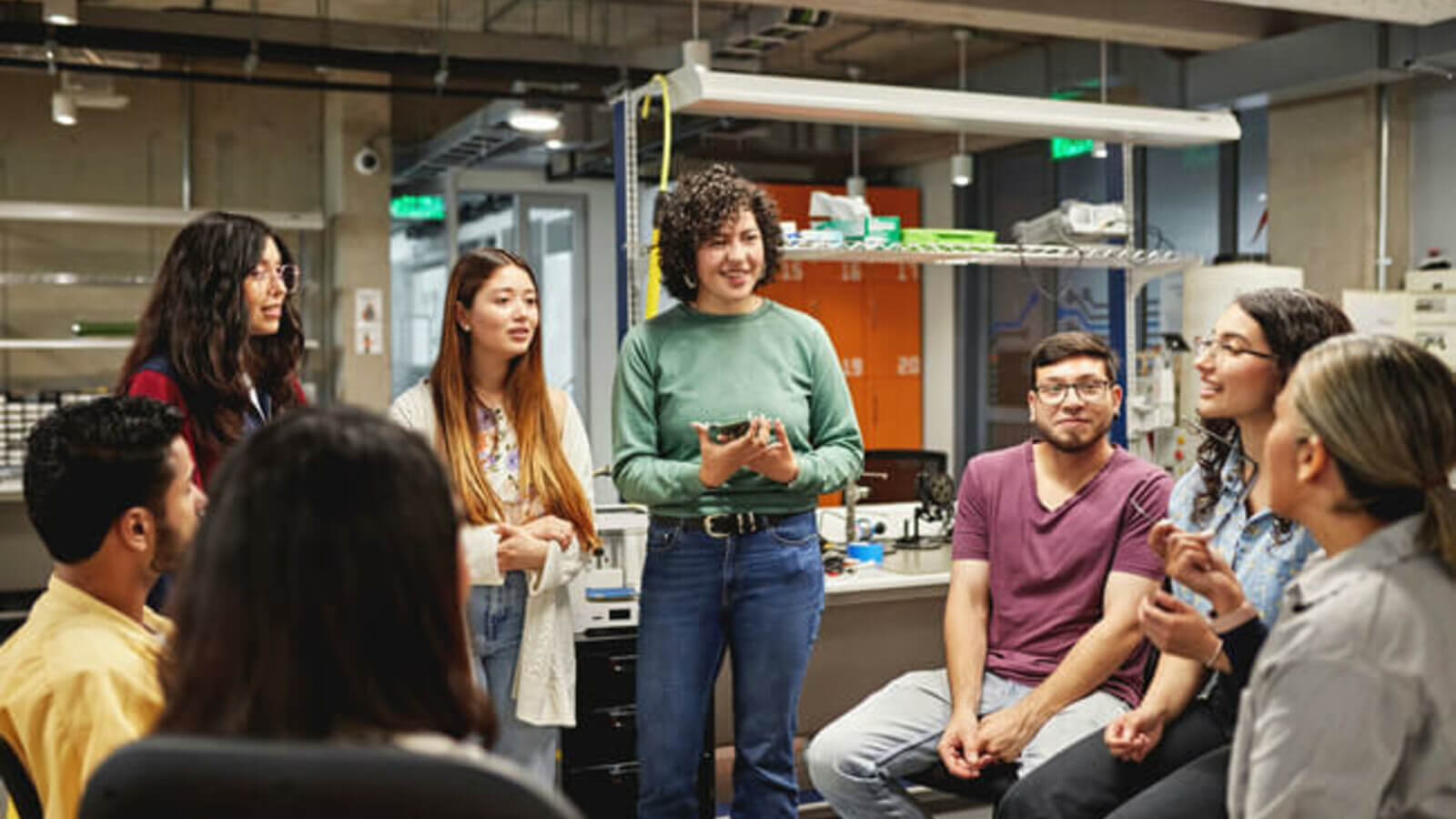 a group of diverse students listening to a speaker during a college tour