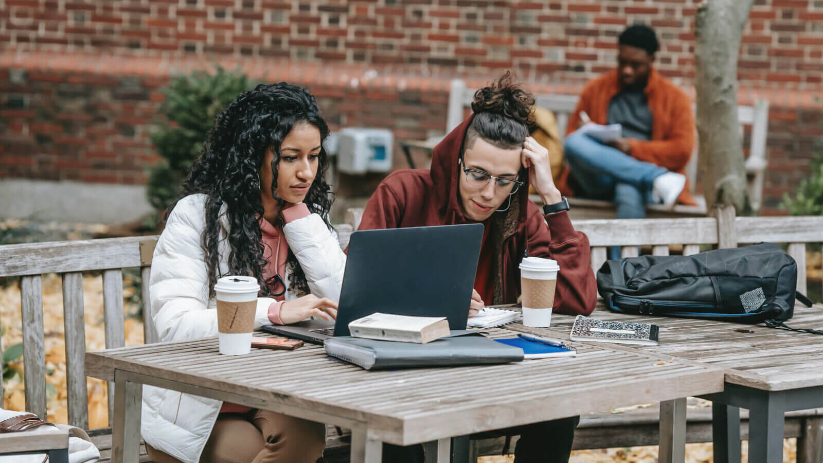 Two students sitting outside at a table