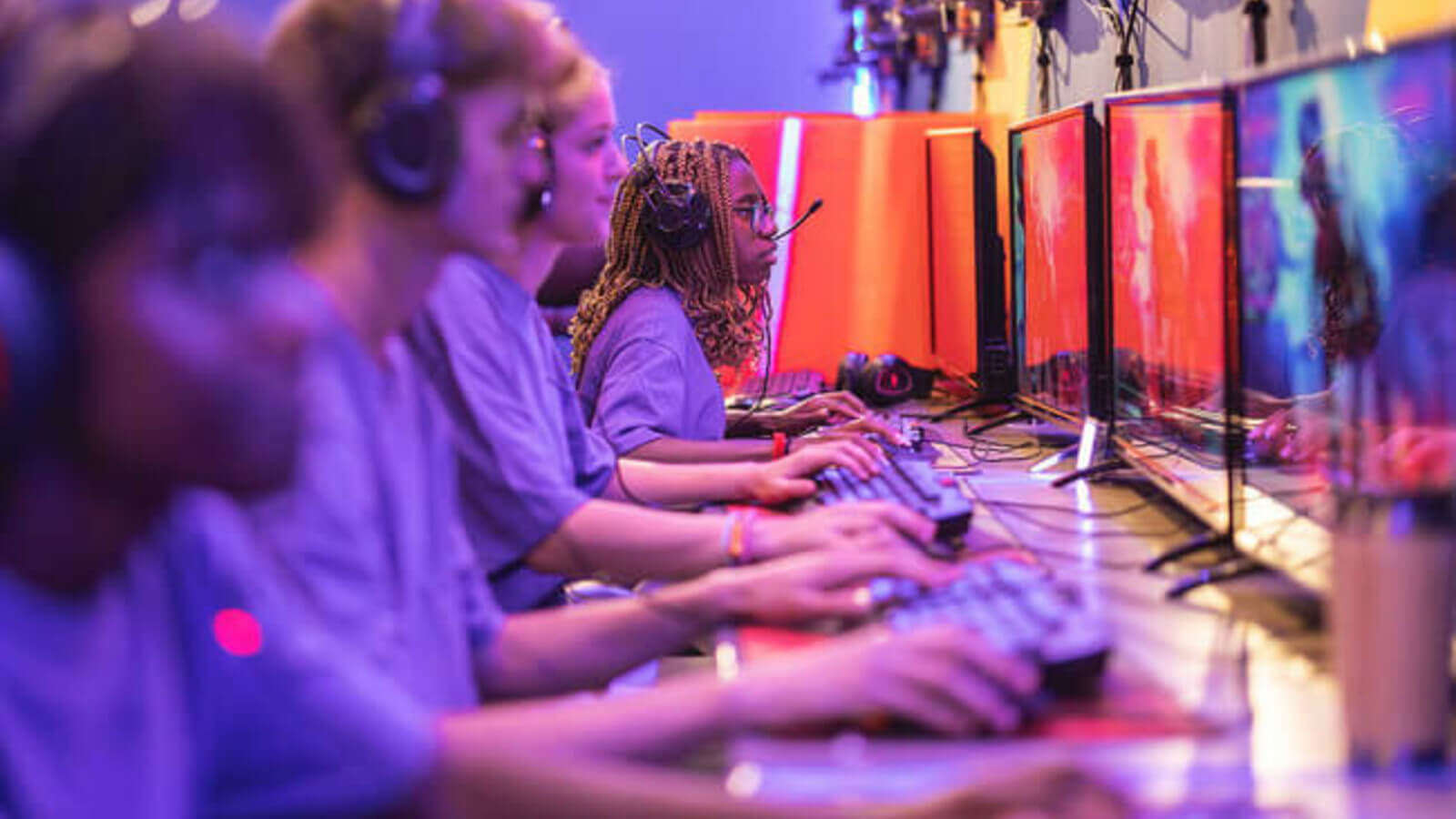 students sit in a row playing esport games on computers