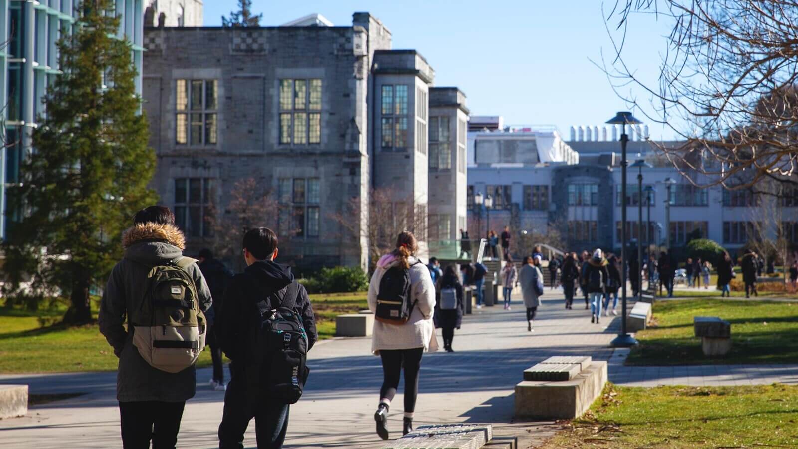 a college campus with students walking down a sidewalk