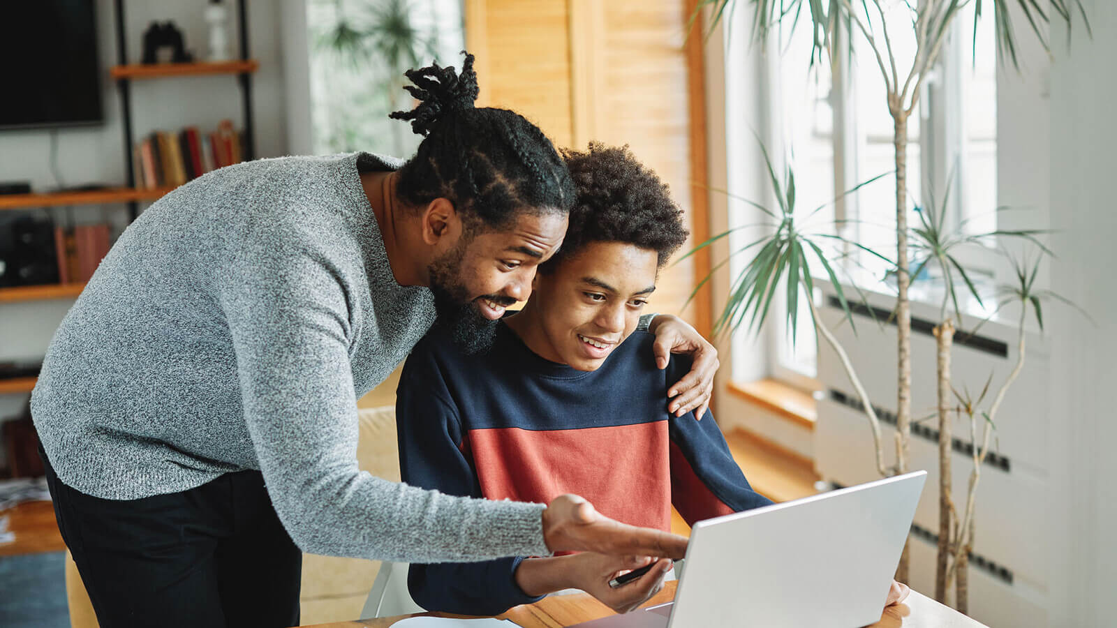A parent and son work together on a college application