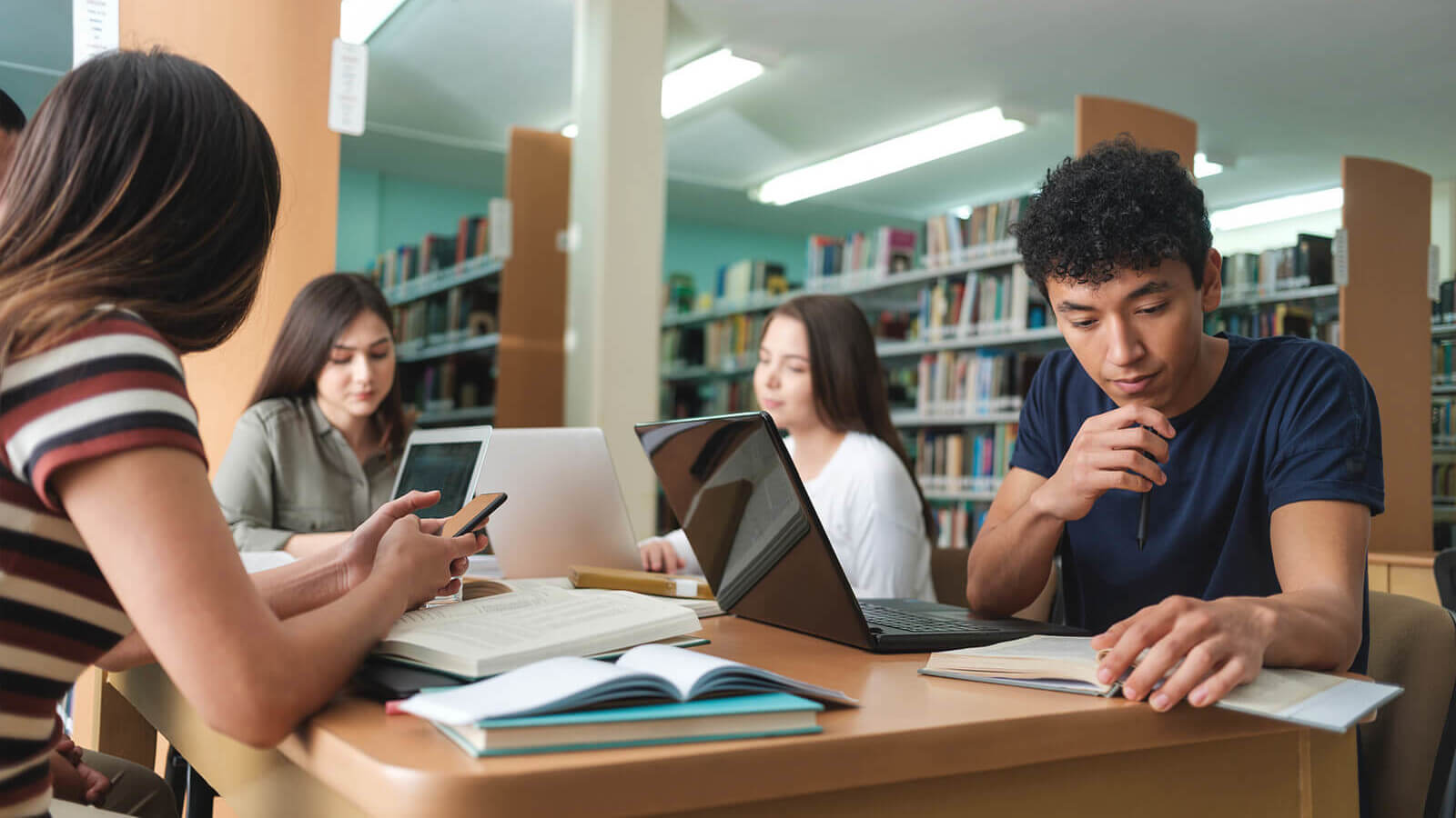 a group of students doing class work in the school library