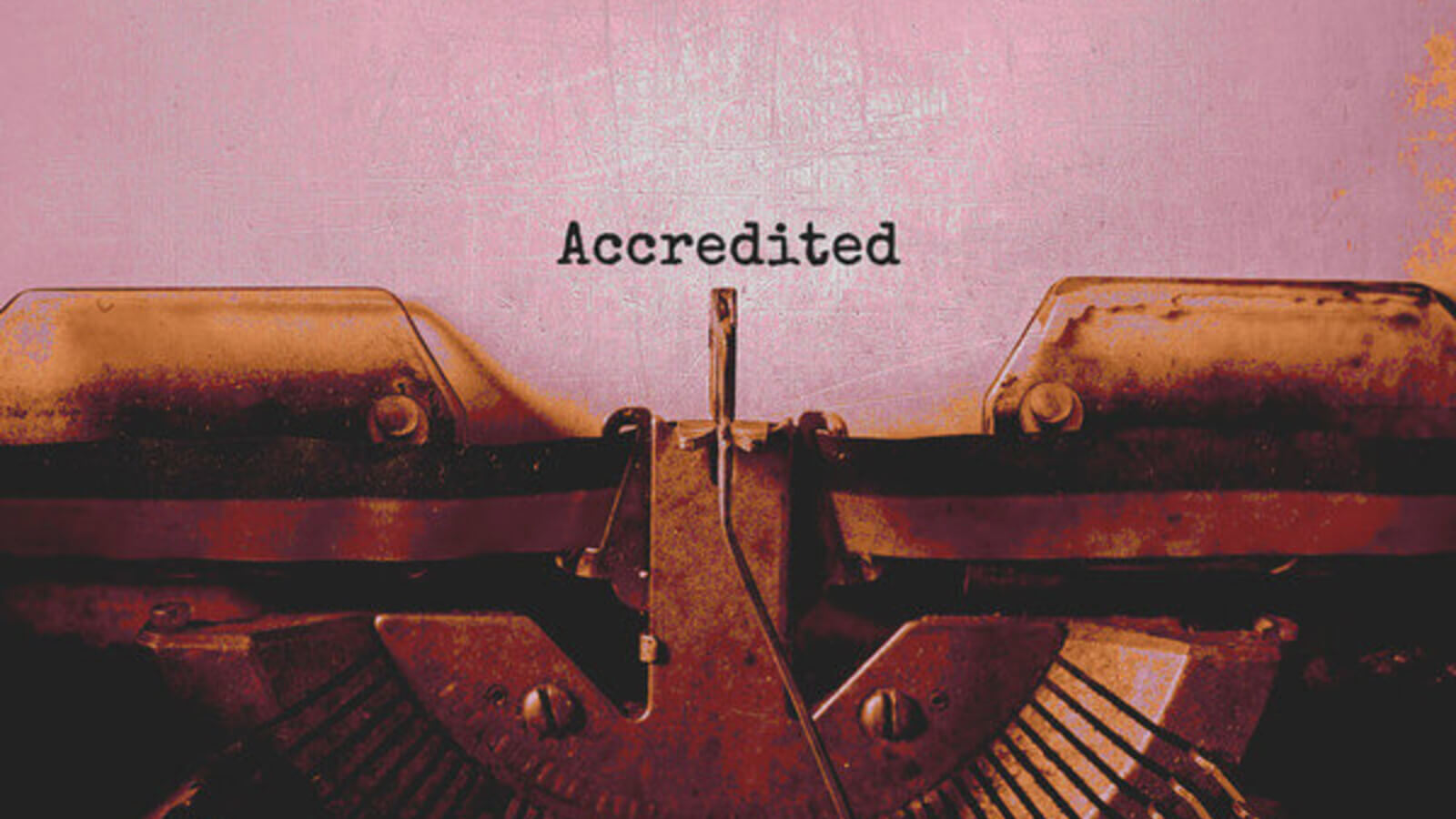 a document and a typewriter with text that says accredited