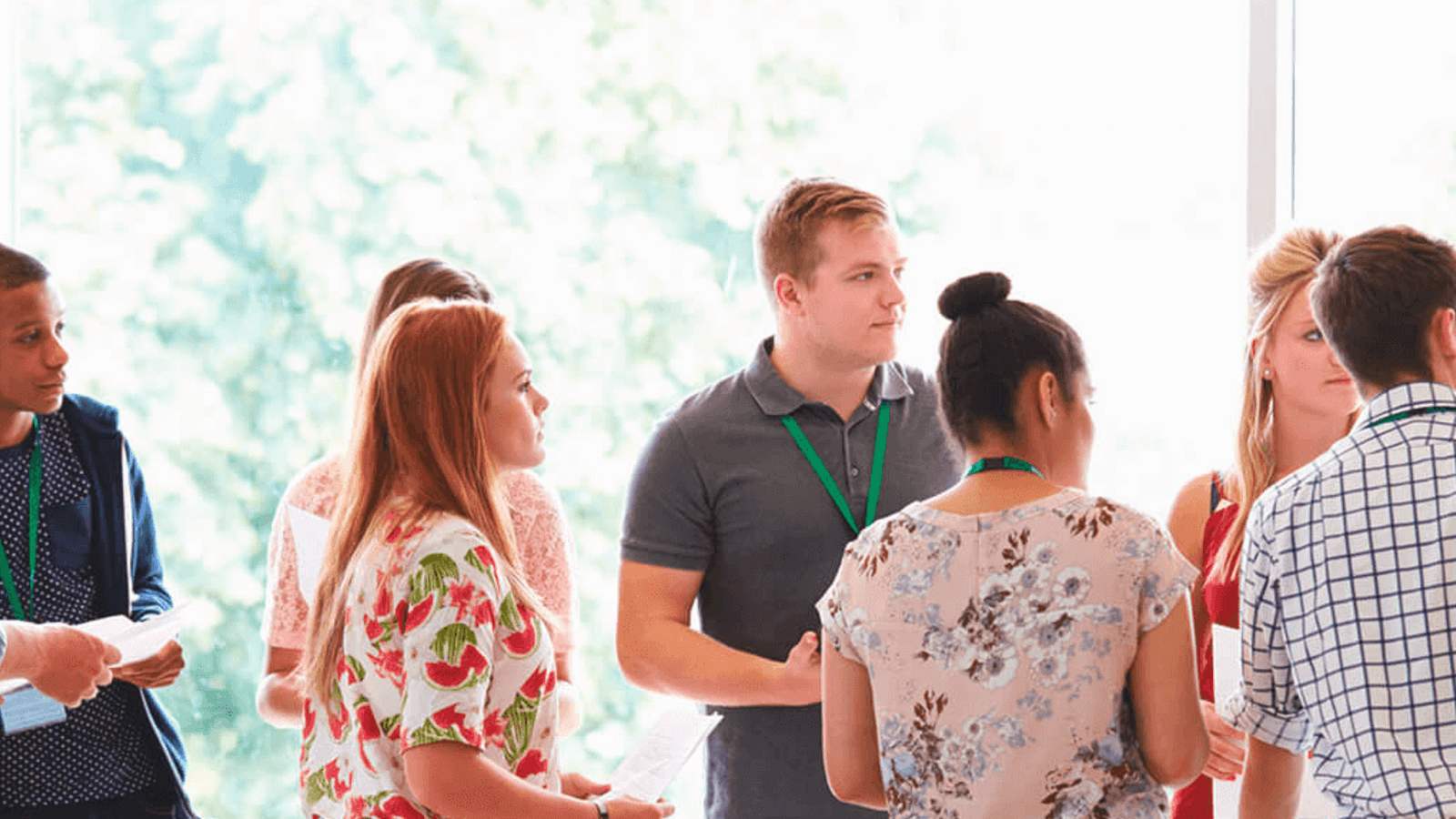 A counselor interacting with a group of students in a hall