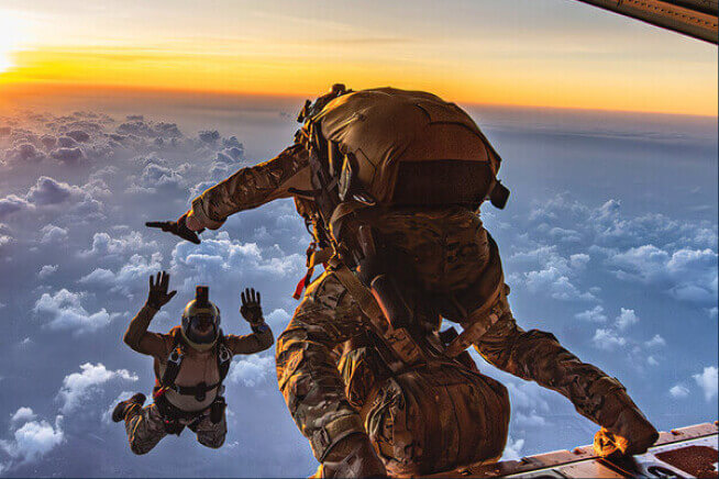 Airmen jump out of a plane
