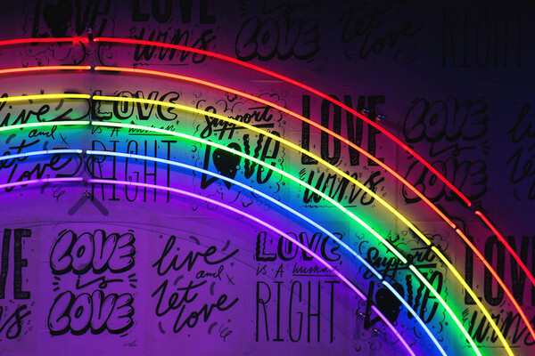 Pride phrases on a wall with a rainbow overlay