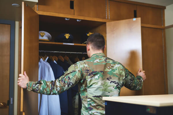 a male student opens the door of a wardrobe