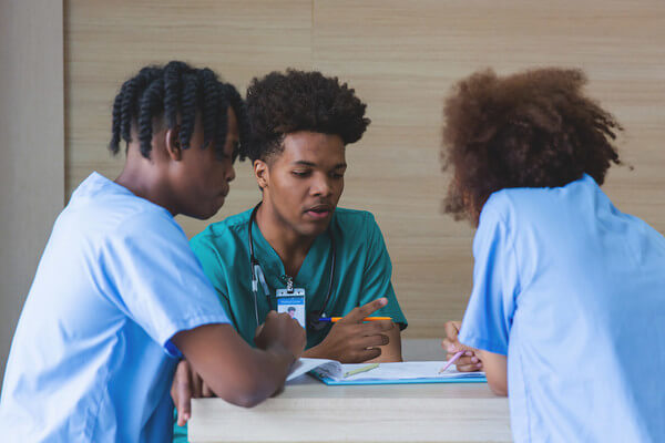 a group of students in scrubs study nursing at an HBCU