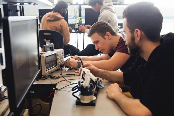 two male students working in a lab on a project