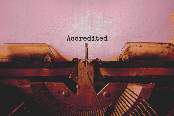 a document and a typewriter with text that says accredited