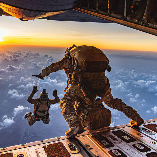 Airmen jump out of a plane