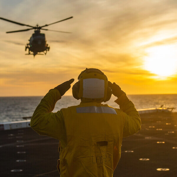 A Navy sailor directs a plan to land on a carrier