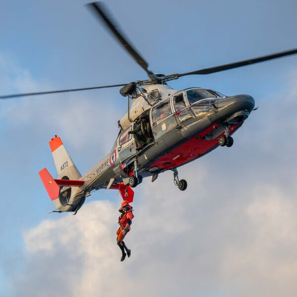 A Coast Guard swimmer jumps from a helicopter